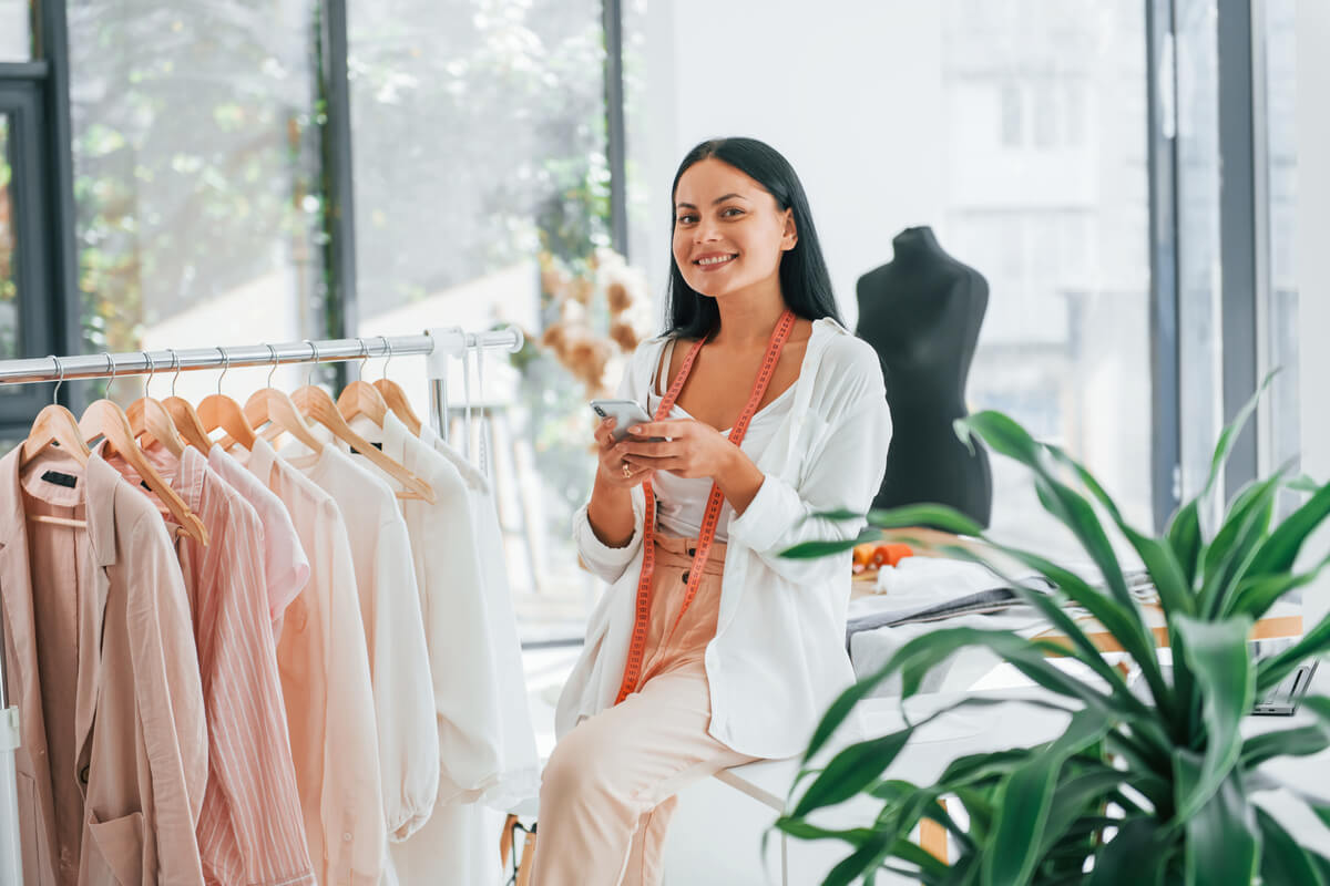 using-phone-seamstress-is-in-her-office-that-is-w-MD9HBNM Baixe o Catálogo de Uniformes ProfissionaisAttelier Visual